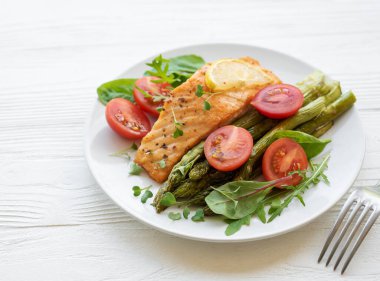 Pişmiş lezzetli somon, yeşil kuşkonmaz ve sebze tabağı. 