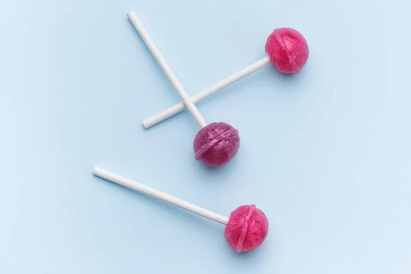 stock image Colorful sweet lollipops over blue background.  Flat lay, top view