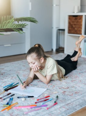 Evde renkli kalemlerle resim çizen kız çocuğu. Ekoloji konsepti, dünyayı boyamak.. 
