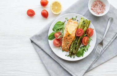 Pişmiş lezzetli somon, yeşil kuşkonmaz ve sebze tabağı. 