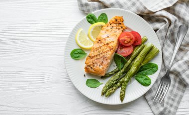 Pişmiş lezzetli somon, yeşil kuşkonmaz ve sebze tabağı. 