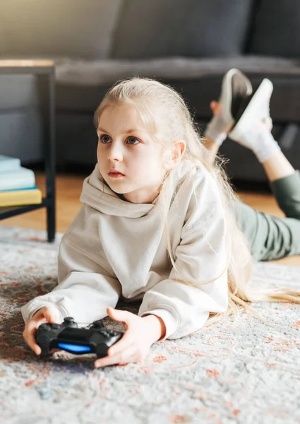 女の子は自宅でゲーム機で遊んでいます — ストック写真