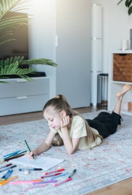 Evde renkli kalemlerle resim çizen kız çocuğu. Ekoloji konsepti, dünyayı boyamak.. 