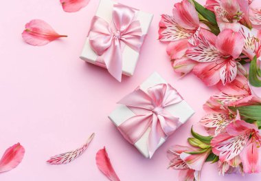 Tebrik metni çerçevesi, Alstroemeria çiçekleri ve pembe arka planda hediye kutuları. Doğal renklerde tebrik kartı. Alstromeria içeren metinler için arka plan. Düz yatış, üst görünüm.