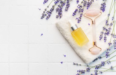 Lavender spa. Lavender  natural essential oil and fresh lavender on a white tile background. clipart