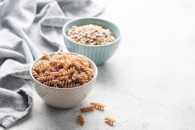 Yeşil mercimek fusilli makarna. Bir kase çiğ makarna ve yeşil mercimek. Glütensiz makarna..