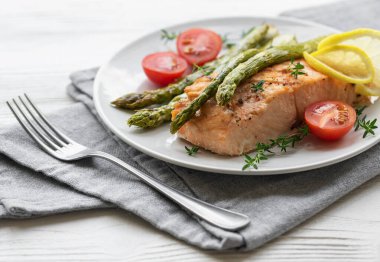 Pişmiş lezzetli somon, yeşil kuşkonmaz ve sebze tabağı. 