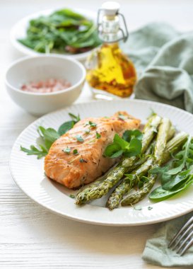 Pişmiş lezzetli somon, yeşil kuşkonmaz ve sebze tabağı. 