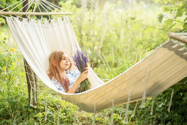 A little girl rests in a hammock  in the summer.  Summer in the village.
