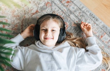 Evde kulaklıkla müzik dinleyen tatlı küçük kız..