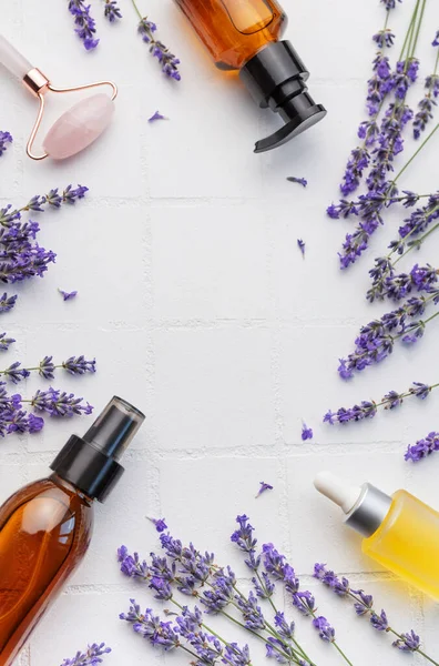 Lavender spa. Lavender  natural essential oil and fresh lavender on a white tile background.