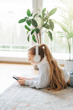 küçük kız dinleme müzik yerde yatarken gülümseyen