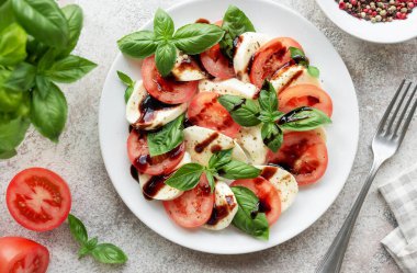 Domatesli Caprese salatası, mozzarella ve fesleğen. Sağlıklı yemek..