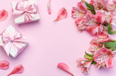 Tebrik metni çerçevesi, Alstroemeria çiçekleri ve pembe arka planda hediye kutuları. Doğal renklerde tebrik kartı. Alstromeria içeren metinler için arka plan. Düz yatış, üst görünüm.