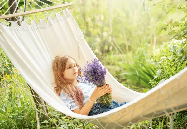 A little girl rests in a hammock  in the summer.  Summer in the village.