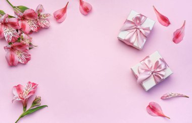 Tebrik metni çerçevesi, Alstroemeria çiçekleri ve pembe arka planda hediye kutuları. Doğal renklerde tebrik kartı. Alstromeria içeren metinler için arka plan. Düz yatış, üst görünüm.