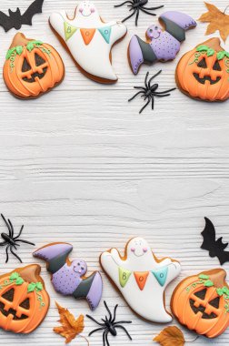 Beyaz ahşap arka planda çok renkli Cadılar Bayramı ev yapımı kurabiyeler.