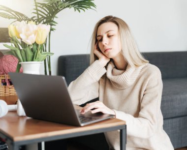 Evde dizüstü bilgisayarla çalışan stresli iş kadını endişeli ve yorgun görünüyor. 