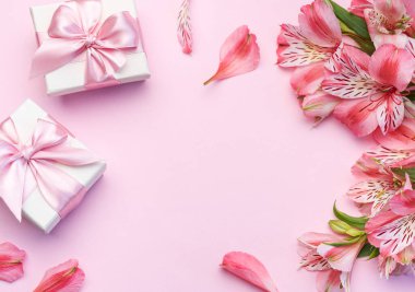 Tebrik metni çerçevesi, Alstroemeria çiçekleri ve pembe arka planda hediye kutuları. Doğal renklerde tebrik kartı. Alstromeria içeren metinler için arka plan. Düz yatış, üst görünüm.