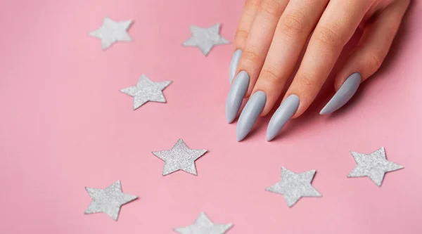 Mãos Com Manicure Cinza Fundo Rosa Com Estrelas Prata — Fotografia de Stock