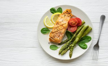 Pişmiş lezzetli somon, yeşil kuşkonmaz ve sebze tabağı. 