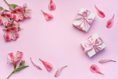 Tebrik metni çerçevesi, Alstroemeria çiçekleri ve pembe arka planda hediye kutuları. Doğal renklerde tebrik kartı. Alstromeria içeren metinler için arka plan. Düz yatış, üst görünüm.