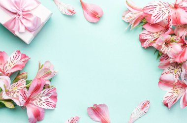 Tebrik metni çerçevesi, Alstroemeria çiçekleri ve açık yeşil arka planda hediye kutuları. Doğal renklerde tebrik kartı. Alstromeria içeren metinler için arka plan. Düz yatış, üst görünüm.