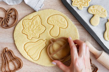 Fırında pişirmek için festival kurabiyeleri hazırlıyorum. Sonbahar yaprakları ve balkabağı şeklinde hazır kurabiyeler..