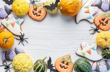 Beyaz ahşap arka planda çok renkli Cadılar Bayramı ev yapımı kurabiyeler.