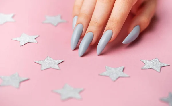 Mãos Com Manicure Cinza Fundo Rosa Com Estrelas Prata — Fotografia de Stock