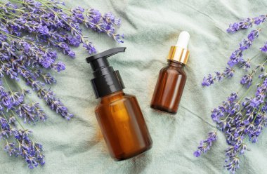 Lavanta kaplıcası. Doğal lavanta yağı ve tekstil arka planında taze lavanta..