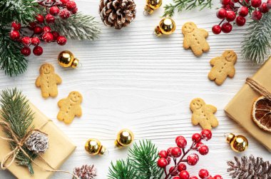 Noel hediyeleri, zencefilli kurabiyeler, beyaz ahşap arka planda noel ağacı süslemeleri.