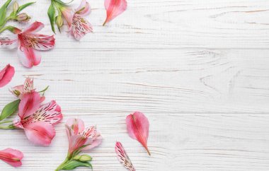 Tebrik metni çerçevesi, tahta bir arka planda Alstroemeria çiçekleri. Doğal renklerde tebrik kartı. Alstromeria içeren metinler için arka plan. Düz yatış, üst görünüm.