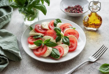 Domatesli Caprese salatası, mozzarella ve fesleğen. Sağlıklı yemek..