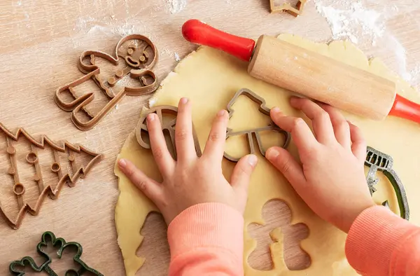 Kinderhände Mit Lebkuchen Auf Hölzernem Hintergrund Draufsicht lizenzfreie Stockbilder