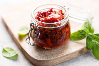 Ev yapımı, kurutulmuş domatesli, taze otlu ve baharatlı kavanoz..