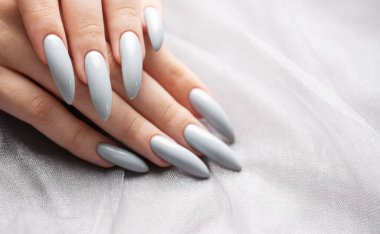 Gri dantelli arka planda gri tırnaklarla boyanmış güzel.