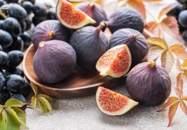 Taze incir ve sonbahar yapraklı koyu üzümler.