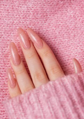 Pembe kazağında güzel manikürlü kadın elleri.