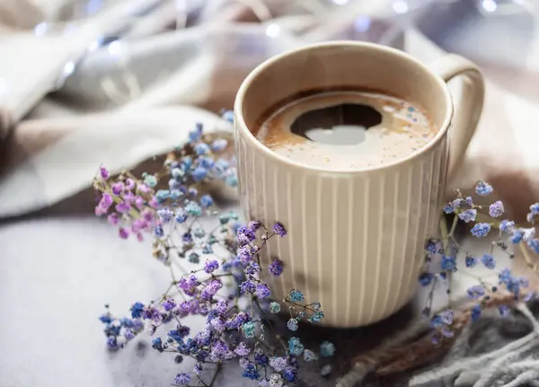 Cup of coffee and a branch of blue gypsophila flowers