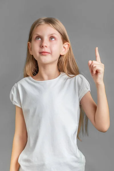 浅色长发的可爱小女孩的画像 直接竖起手指 免版税图库照片