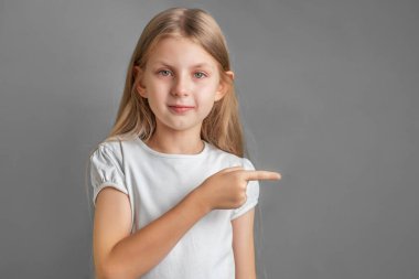 Mutlu ve sevimli çocuk kız şirket ya da ürün gösteriyor ya da destekliyor