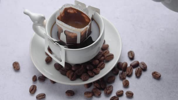 新鮮なドリップコーヒーを生産するためにローストコーヒーのカップに注がれた熱湯 ドリップコーヒーバッグでコーヒーを作る — ストック動画