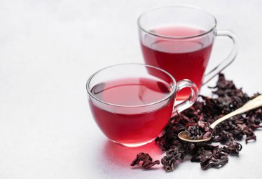 Hibiscus çayı ve cam bardak. Masada bir fincan amberçiçeği çayı.