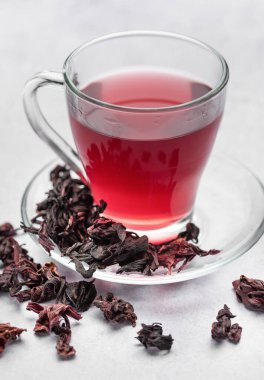 Hibiscus çayı ve cam bardak. Masada bir fincan amberçiçeği çayı.