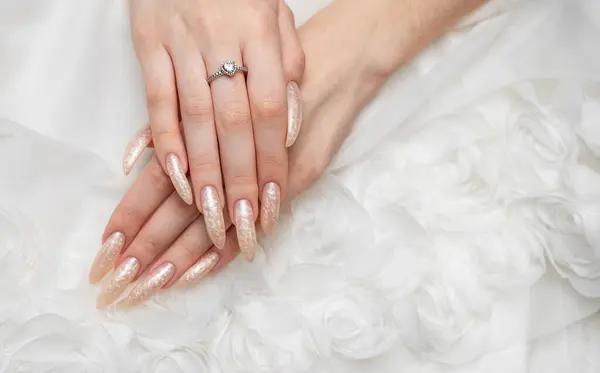 Manicured nails with pearlescent nail polish.  The nails are covered with pearl gel polish on white background