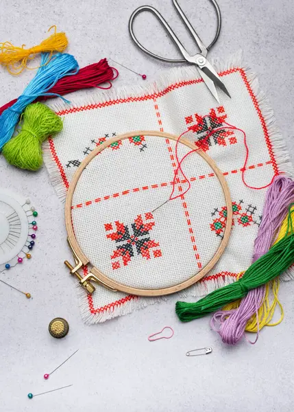 Masada renkli iplikler ve çeşitli dikiş aksesuarları olan nakış.