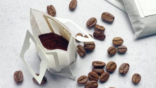 Druppel Koffie Papieren Zakken Met Koffiebonen Een Grijze Betonnen Achtergrond — Stockvideo