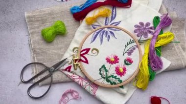 Elle işleme işlemi beyaz kumaşın üzerine renkli ipliklerle işlenmiş bir peçete.. 