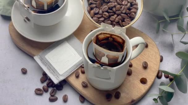 カップにコーヒーが入ったコーヒーバッグをドリップ 自宅で新鮮なコーヒーを作る — ストック動画